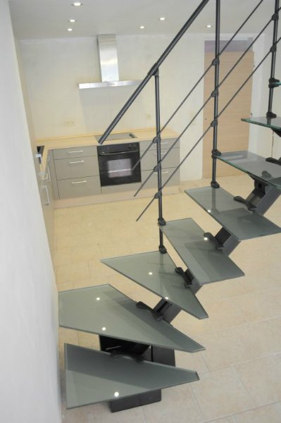 Фото. Модульная лестница Do-Up(Бельгия) на металлическом центральном косоуре с забежными ступенями, 11 ступеней из стекла.